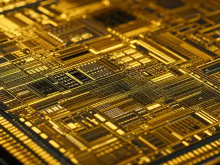 NXP Semiconductors NL0009538779 Makroaufnahme zeigt goldene Leiterbahnen und Strukturen auf Silizium-Chip detailliert - Foto: THN