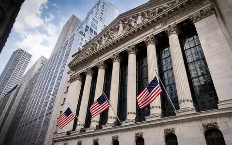 NVR Inc. US62944T1051 dokumentiert Börsen-Editorial mit NYSE-Fassade, Säulen und wehenden amerikanischen Flaggen - Foto: THN