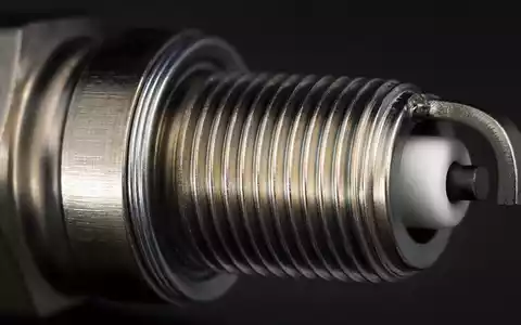 O'Reilly Automotive (US67103H1077) Aktienbild: Makrofotografie einer Zündkerze mit sichtbarem Metallgewinde und Keramikisolator - Foto: THN