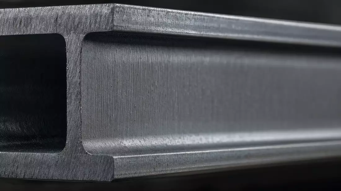 Extreme Makroaufnahme eines Stahlträgerprofils mit sichtbarer gebürsteter Metalltextur in Grautönen