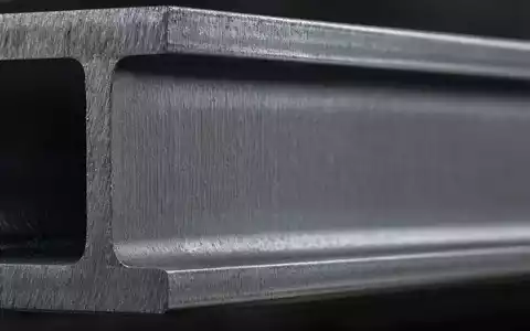 Nucor Corporation US6703461052 gezeigt als Makroaufnahme einer Stahlprofil-Textur mit sichtbarer gebürsteter Metallmaserung und Lichtreflexen - Foto: THN