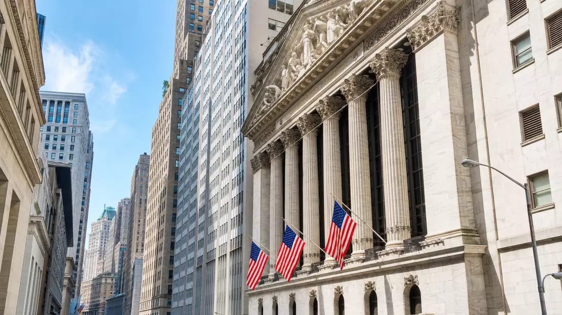 Editorialfoto der klassizistischen Börsenfassade an der Wall Street mit amerikanischen Flaggen und Säulen