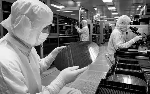 Schwarzweiß-Reportagebild aus einem Halbleiter-Reinraum, passend zu Microchip Technology, ISIN US5950171042, Ingenieure prüfen Silizium-Wafer - Foto: THN