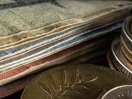 Makroaufnahme von Banknoten und Münzen illustriert Investec plc, ISIN GB00B17BBQ50, Detailfoto des Finanzsektors - Foto: THN