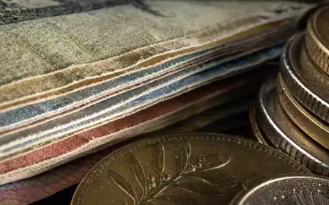 Makroaufnahme von Banknoten und MĂŒnzen illustriert Investec plc, ISIN GB00B17BBQ50, Detailfoto des Finanzsektors - Foto: THN