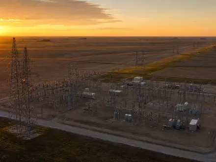 Evergy Umspannwerk US30034W1064 bei goldenem Morgenlicht über der flachen Kansas-Prärie mit Hochspannungsmasten - Foto: THN