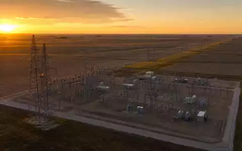 Evergy Umspannwerk US30034W1064 bei goldenem Morgenlicht über der flachen Kansas-Prärie mit Hochspannungsmasten - Foto: THN