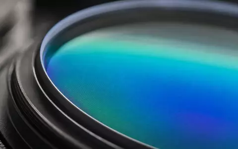 EssilorLuxottica FR0000121667 zeigt Makroaufnahme einer Brillenlinse mit schillernder Antireflexbeschichtung in detailreicher blaugrüner Nahaufnahme - Foto: THN