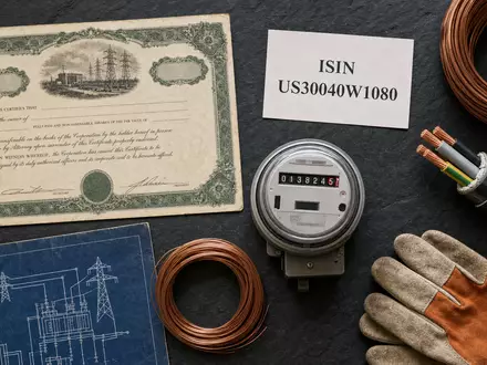 Eversource Energy Flatlay mit Aktienzertifikat und ISIN Karte US30040W1080 Kupferkabel Stromzähler Schutzhandschuhe - Foto: THN