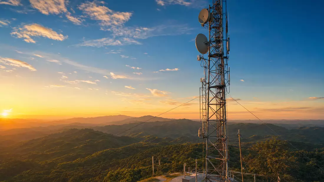 Fotorealistischer Mobilfunkturm auf Berggipfel bei Sonnenuntergang