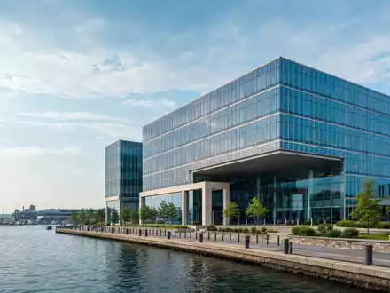 Hiscox Ltd BMG4593F1389 zeigt fotorealistisch ein modernes Bürogebäude eines internationalen Spezialversicherers am Meer - Foto: THN