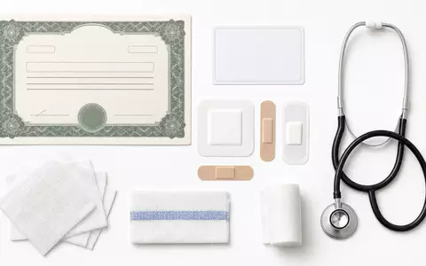 ConvaTec Group Plc GB00BD3VFW73 arrangiert Flatlay mit Aktienzertifikat, ISIN-Karte und medizinischen Wundversorgungsutensilien übersichtlich - Foto: THN
