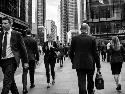 Man Group plc JE00BJ1DLW90 dokumentiert Schwarzweiß-Reportage aus Finanzdistrikt mit Börsenhändlern und Vermögensverwaltungs-Atmosphäre in London - Foto: THN