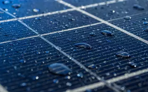 SMA Solar Technology DE000A0DJ6J9 zeigt eine Makroaufnahme einer monokristallinen Solarzelle mit Wassertropfen - Foto: THN