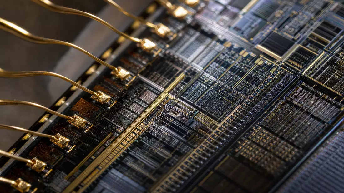 Extreme Nahaufnahme eines Mikrochips mit goldenen Bonddrähten und Schaltkreisen