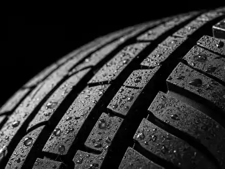 Makroaufnahme eines Reifenprofils mit Wassertropfen zeigt ein zentrales Produktdetail von Sixt SE DE0007231334 - Foto: THN