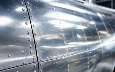 Alaska Air Group Inc. US0116591092 – Makrofotografie polierter Flugzeug-Aluminium-Rumpfhaut mit sichtbaren Nieten - Foto: THN