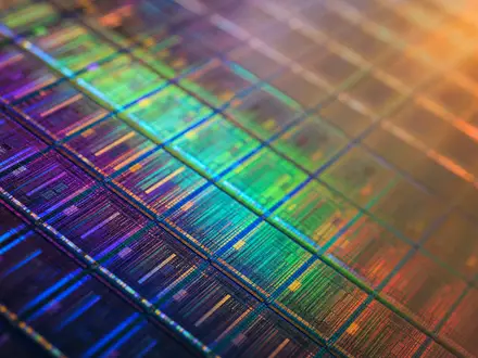 AIXTRON SE DE000A0WMPJ6 Makro-Fotografie der Wafer-Oberfläche mit schillernder Regenbogen-Interferenz in Violett Gold Grün - Foto: THN