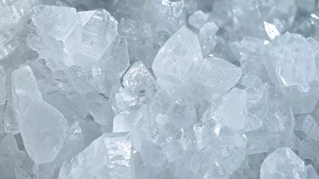 Extreme Makrofotografie weißer Lithiumkarbonatkristalle mit Lichtreflexen