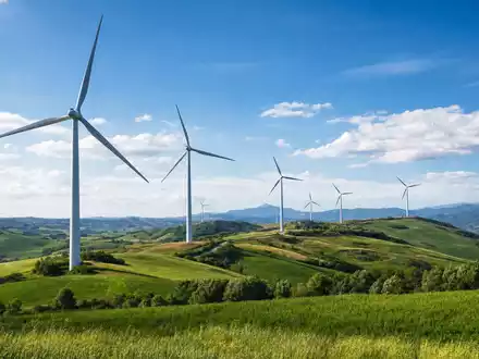 Fotorealistischer Windpark auf italienischen Hügeln symbolisiert ERG S.p.A. IT0001157020 im Bereich erneuerbare Energien heute - Foto: THN