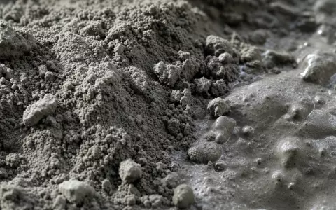 Makroaufnahme von Zementpulver zeigt das Kerngeschäft von Buzzi S.p.A., ISIN IT0001347308, im Baustoffsektor - Foto: THN
