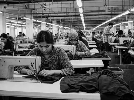 Schwarzweiße Reportage-Aufnahme einer Textilmanufaktur veranschaulicht Produktionsprozess der Ralph Lauren Corp Aktie ISIN US7512121010 im Bekleidungssektor - Foto: THN