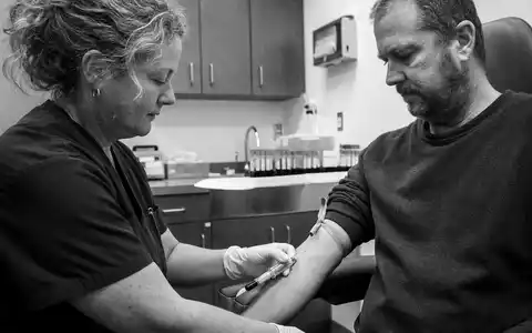 Quest Diagnostics US74834L1008 dokumentiert generische Blutentnahme in Schwarzweiß-Reportage-Fotografie mit authentischer klinischer Atmosphäre - Foto: THN
