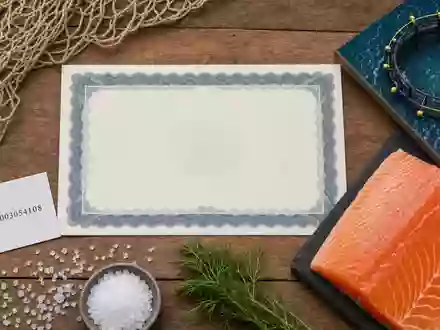 Flatlay-Arrangement mit ISIN-Karte NO0003054108, Aktienzertifikat und Lachsfilet visualisiert Mowi ASA als Investmentobjekt - Foto: THN