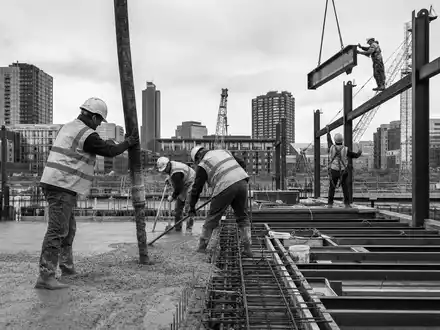 Schwarzweiß-Reportage dokumentiert Bauarbeiter, passend zu Morgan Sindall Group plc, ISIN GB0006005892, im Baugewerbe tätig - Foto: THN