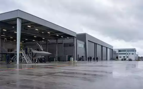 Saab AB (ISIN SE0000112385) zeigt fotorealistisch einen Flugzeughangar mit Wartungsteam an einem Rüstungsstandort - Foto: THN
