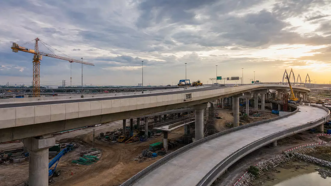 Fotorealistische Baustelle einer Autobahnbrücke bei Sonnenuntergang mit Baukran
