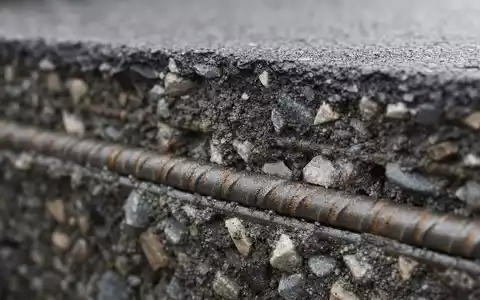 Makroaufnahme von Asphalt und Bewehrungsstahl zeigt Baumaterial-Grundlage des Geschäfts von Sacyr S.A. (ISIN ES0182870214) - Foto: THN