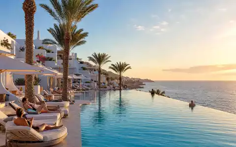 Meliá Hotels International S.A. zeigt sonnigen mediterranen Hotelpool mit Liegestühlen und Palmen, ISIN ES0176252718 - Foto: THN