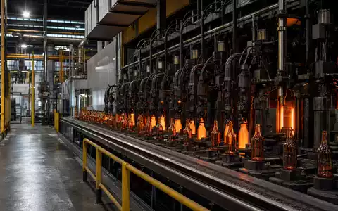 Fotorealistische Glasflaschen-Fabrikhalle mit glühenden Formmaschinen zeigt beispielhaft Vidrala S.A. Kernbranche, ISIN ES0183746314 Referenz - Foto: THN