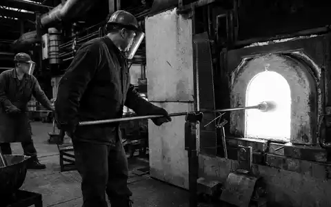 Dokumentarische Schwarzweiß-Reportage aus einer traditionellen Glashütte veranschaulicht Vidrala S.A. typischen Produktionsalltag, ISIN ES0183746314 im Fokus - Foto: THN