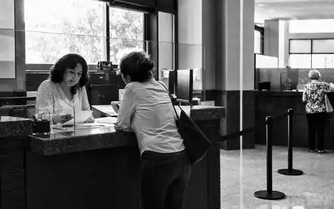 US Bancorp (ISIN US9029733048) dokumentiert in Schwarzweiß eine Kundenberatung am Schalter einer Bankfiliale - Foto: THN