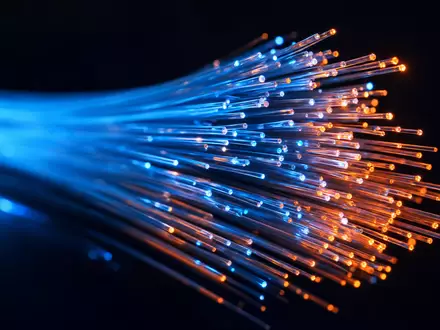 Verisign Inc. (US92343E1029) steht für Netzwerktechnik, dargestellt durch leuchtende Glasfaserkabel in extremer Makroaufnahme - Foto: THN