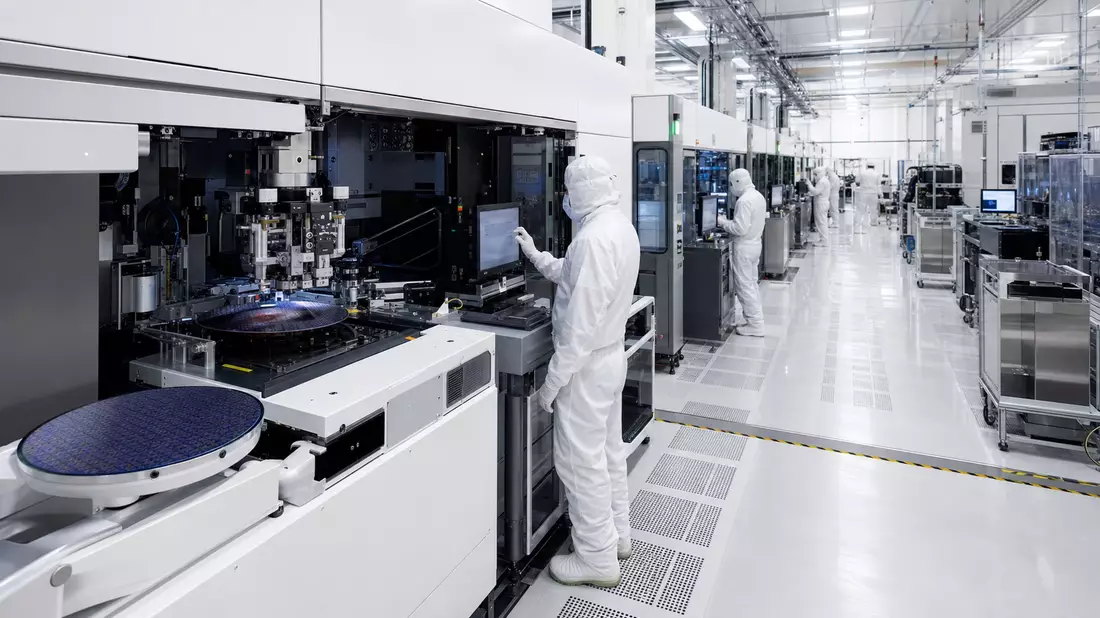 Reinraum-Fertigungsanlage für Halbleiterchips mit Technikern in Schutzanzügen