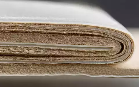 SIG Group AG CH0435377954 zeigt eine Makroaufnahme von Kartonverbundmaterial mit feinen Schichten als technisches Detailmotiv - Foto: THN