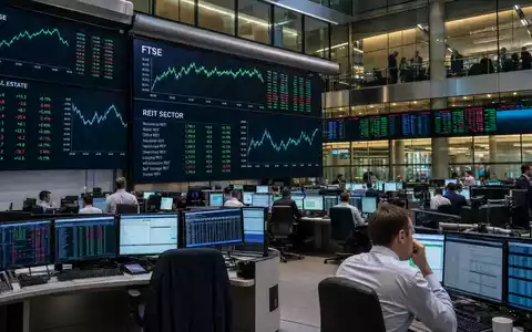Big Yellow Group plc (ISIN GB0002869419): Börsen-Editorial mit FTSE-Kürzel und REIT-Sektor-Charts auf Handelsraum-Bildschirmen - Foto: THN