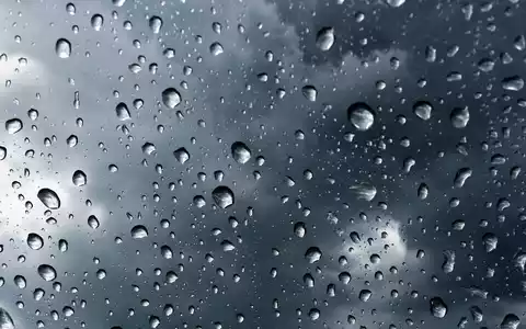 Hannover Rück SE (DE0008402215) versichert Wetterrisiken, symbolisiert durch diese Makroaufnahme von Regentropfen vor Sturmwolken - Foto: THN