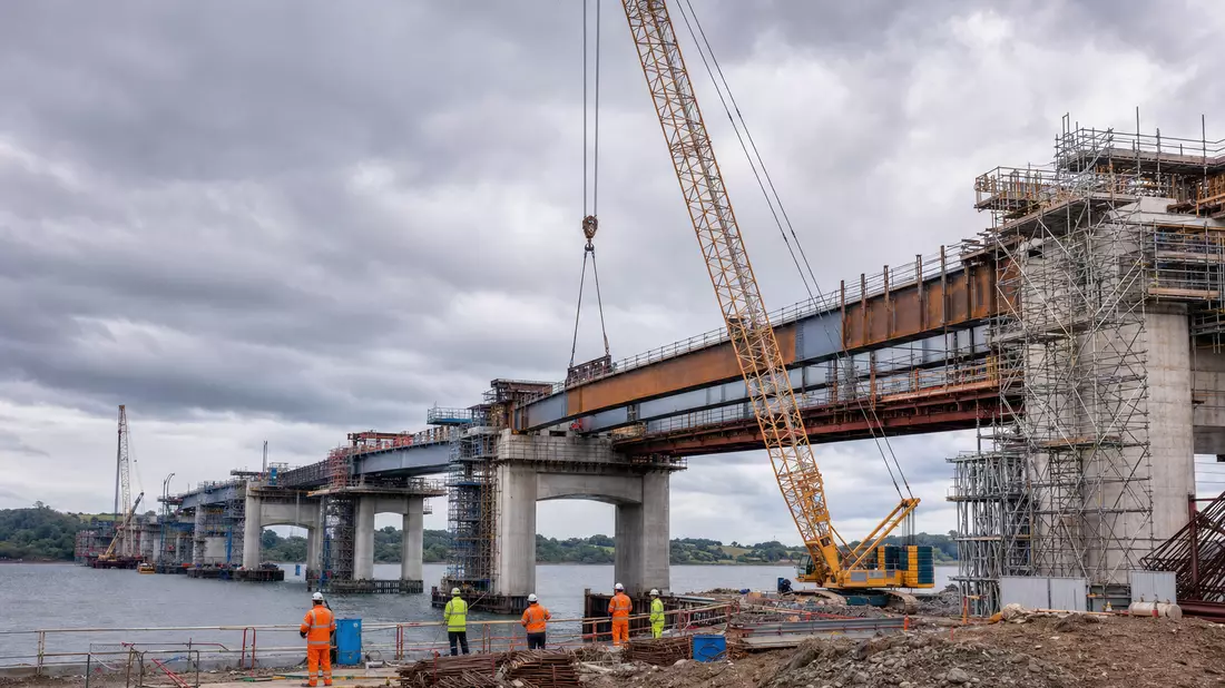Fotorealistische Brückenbaustelle mit Kran, Gerüst und Arbeitern in Sicherheitskleidung