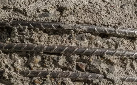 Balfour Beatty plc (ISIN GB0002422382) fokussiert makroaufnahmeartig strukturierten Beton mit sichtbaren Stahlbewehrungsstäben im Detail - Foto: THN