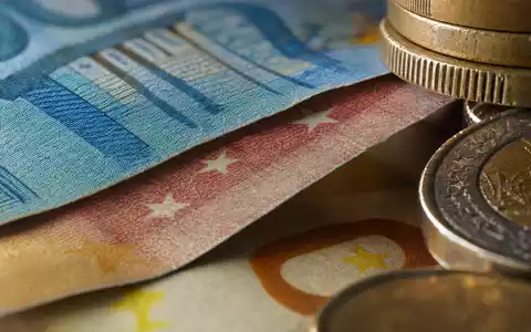 Makroaufnahme von Euro-Banknoten und Münzen veranschaulicht das Kerngeschäft von Bankinter S.A. (ISIN ES0113679137) im Bankensektor - Foto: THN