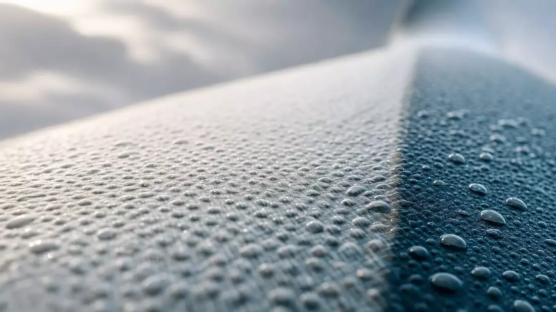 Makrofoto der strukturierten Oberfläche einer Windturbinenschaufel mit Wassertropfen