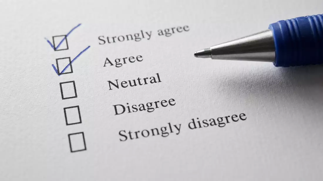 Makroaufnahme eines Umfragebogens mit Checkbox-Markierungen und Stift