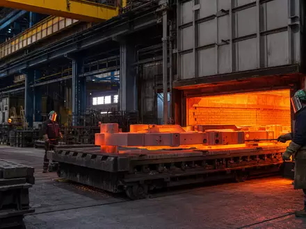 Fotorealistische Aufnahme einer Wärmebehandlungsanlage von Bodycote plc, ISIN GB00B3FLWH99, mit glühenden Stahlteilen im Industrieofen - Foto: THN