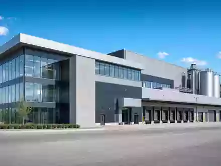 Modernes Architektur-Render einer Industrieanlage mit Glasfassade und Silos, thematisch zu Bodycote plc, ISIN GB00B3FLWH99 - Foto: THN