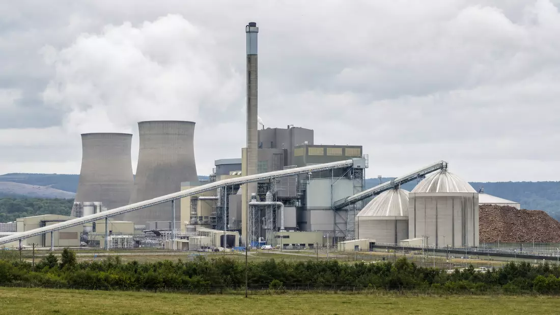 Biomasse-Kraftwerk mit Kühltürmen und Pelletlagern in britischer Landschaft