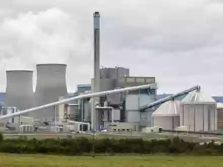 Fotorealistische Ansicht eines Biomasse-Kraftwerks von Drax Group plc, ISIN GB00B1VNSX38, mit Kühltürmen und Lagersilos - Foto: THN